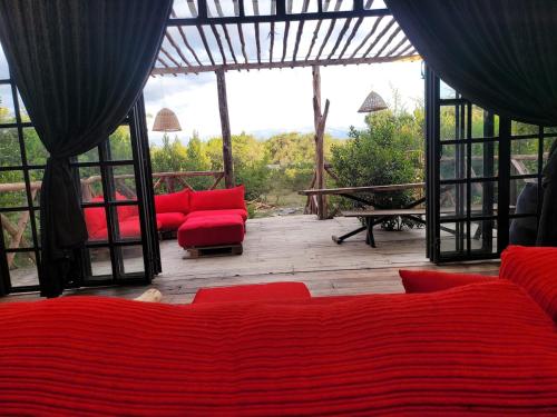 a living room with red couches and a view at DesertDewEstate in Nanyuki