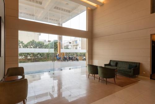 a lobby with green furniture and a large window at Private Cinema Apartment By Buddies Home in Greater Noida