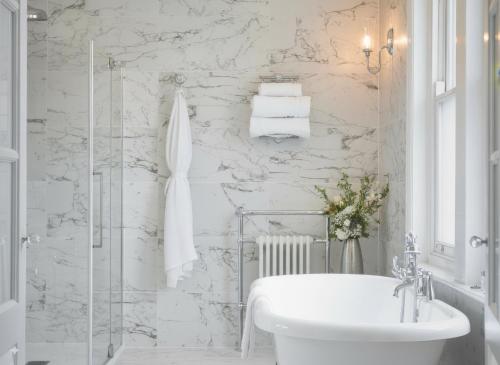 a white bathroom with a tub and a sink at Bathen House Boutique Hotel in Bath