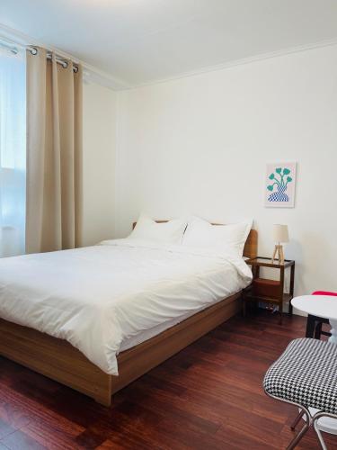 a bedroom with a large bed with white sheets at 호텔 마노앤디또 in Kuŏm-ni