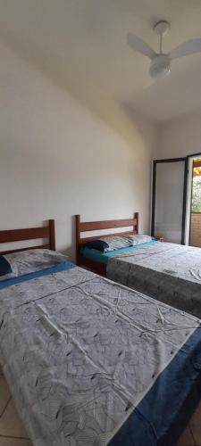 twee eenpersoonsbedden in een kamer met een raam bij Chalés Do Sol in Boracéia