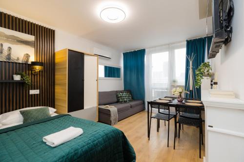a bedroom with a bed and a desk and a couch at UNITApartaments Short Rent Apartment in Warsaw by Metro Station Rondo ONZ Apart with 3bedrooms 23 in Warsaw
