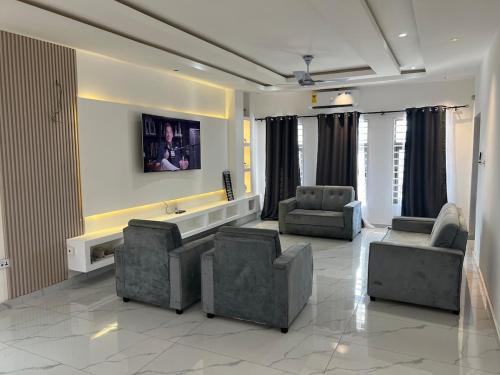 a living room with two chairs and a couch and a table at Home in Gbawe in Gbawe