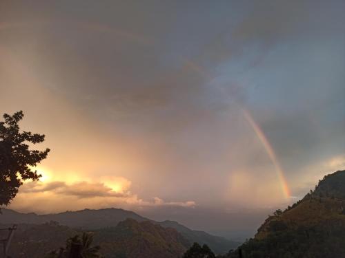 a rainbow in the sky over a mountain range at Ella Elysium Escapes in Ella