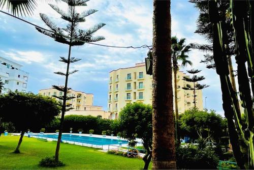 a view of a resort with a swimming pool and palm trees at LUX Centre Malabata Le Printemps Complex in Tangier