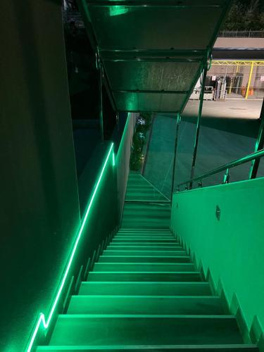 a staircase with green lights on the side of a building at Ema, Asja, Eda Apartments in Zenica