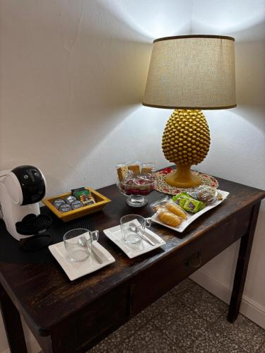 a table with a lamp and plates of food on it at Etna Docet in Nicolosi