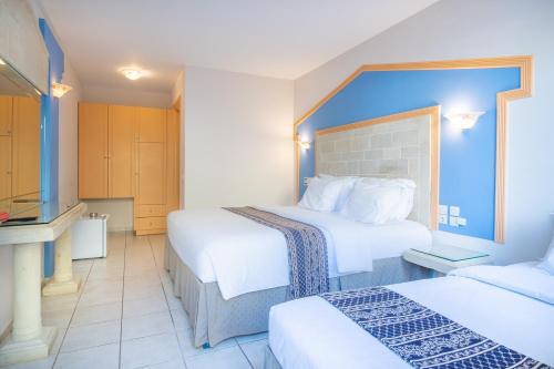 a hotel room with two beds and a bathroom at Astoria Hotel in Agia Galini