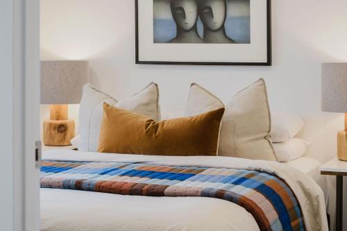 a bedroom with a bed with white sheets and pillows at Sheppard Art House Townhouse in Bright