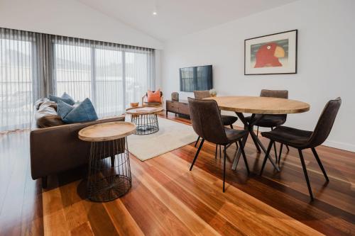 a living room with a table and a couch at Sheppard Art House Townhouse in Bright