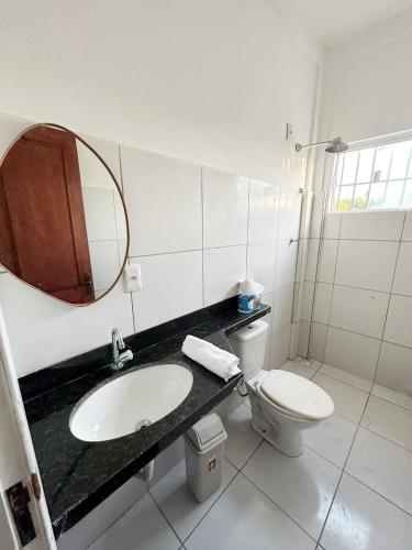 a bathroom with a sink and a toilet and a mirror at Lar de Maria Aguiar in Barreirinhas