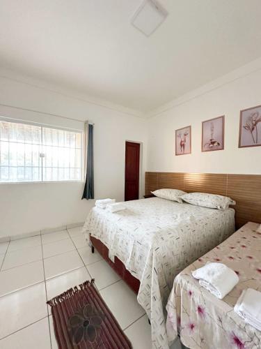 a bedroom with two beds and a window at Lar de Maria Aguiar in Barreirinhas