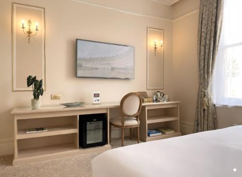 a hotel room with a desk and a television on the wall at Bathen House Boutique Hotel in Bath