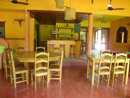 comedor con mesa de madera y sillas en Pousada O Cantinho, en Arraial d'Ajuda