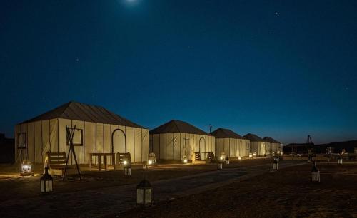 a row of domed buildings at night at Exceptional Luxury Camp in Merzouga
