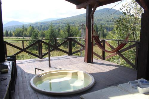 a bath tub sitting on top of a deck at містечко Швейцарське in Dragonya