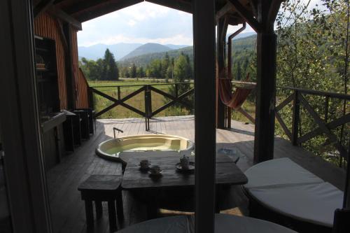 a bathroom with a tub and a balcony with a view at містечко Швейцарське in Dragonya