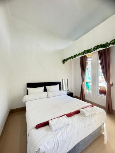 a bedroom with a large white bed with two white pillows at Private Room in Villa Near Nusa Dua Beach Bali in Nusa Dua