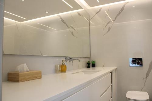 a white bathroom with a sink and a toilet at LuxApart74 l Comfy & Minimal Stay in Ierapetra in Ierápetra