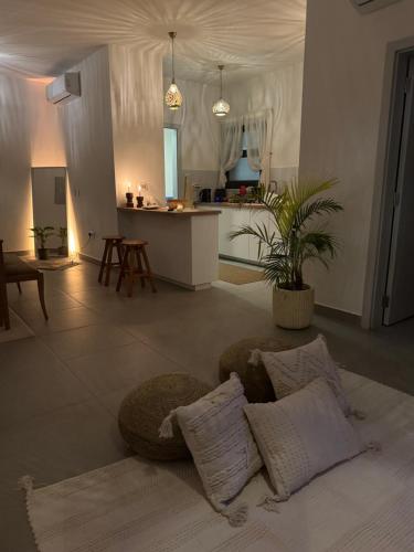 ein Wohnzimmer mit Couch und Küche in der Unterkunft Cozy Garden Flat with Full Kitchen in Madīnat aţ Ţalāʼi‘