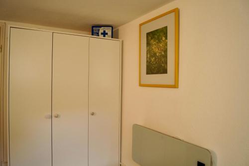 Una sala de estar con un mueble blanco y un televisor. en Grüne Oase Souterrain, en Buxheim