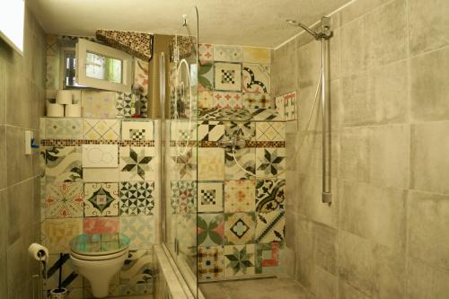 y baño con ducha, aseo y azulejos. en Grüne Oase Souterrain, en Buxheim