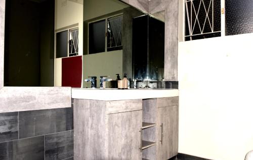 a bathroom with a sink and a mirror at Private Guest suite in Ferndale in Johannesburg