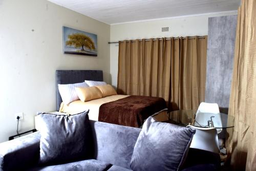 a bedroom with a bed and a couch at Private Guest suite in Ferndale in Johannesburg