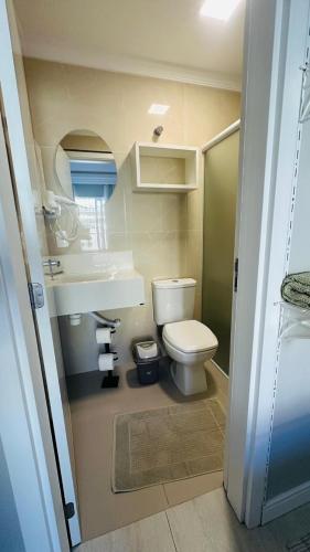 a small bathroom with a toilet and a sink at Bouganville Guest House BC in Balneário Camboriú