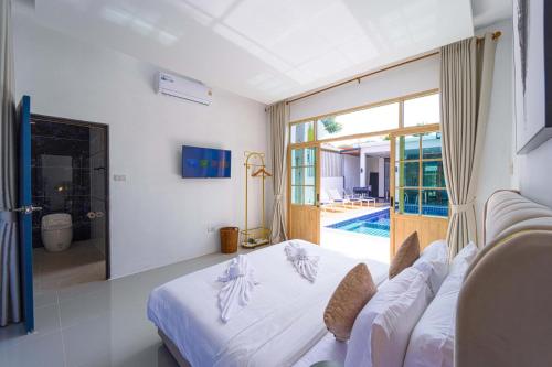 a bedroom with a white bed and a large window at Beautiful 4-Bedroom Pool Villa - BL9 in Hua Hin