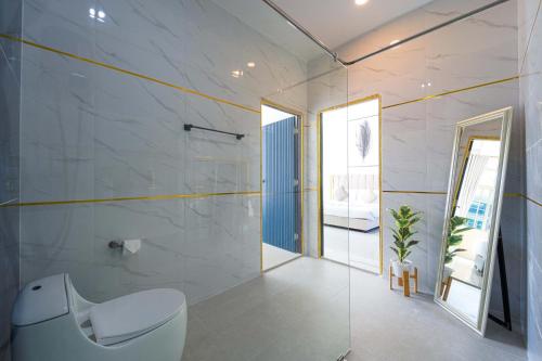 a bathroom with a white toilet and a mirror at Beautiful 4-Bedroom Pool Villa - BL9 in Hua Hin