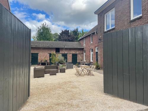 a courtyard with chairs and tables in a brick building at logeren in maastricht in Maastricht
