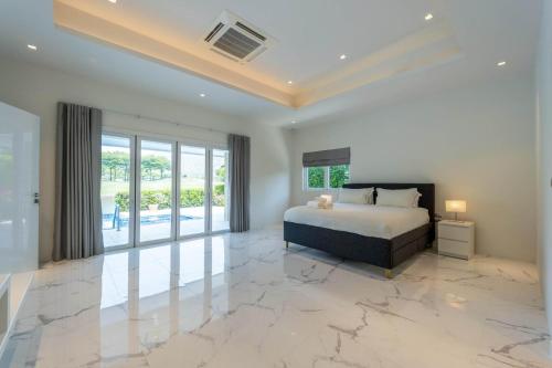 a bedroom with a bed and a large marble floor at Nice 3BR with Golf Course View - BMG3 in Hua Hin
