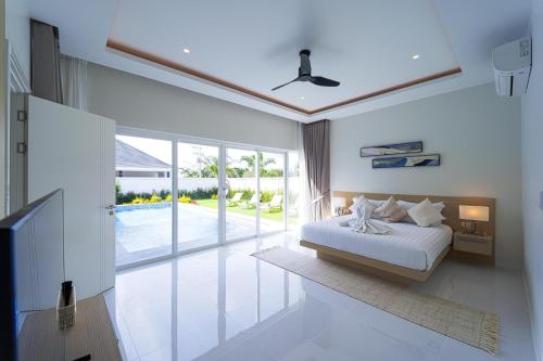 a bedroom with a bed and a view of a pool at Modern 3 Bedroom Villa - AS1 in Hua Hin