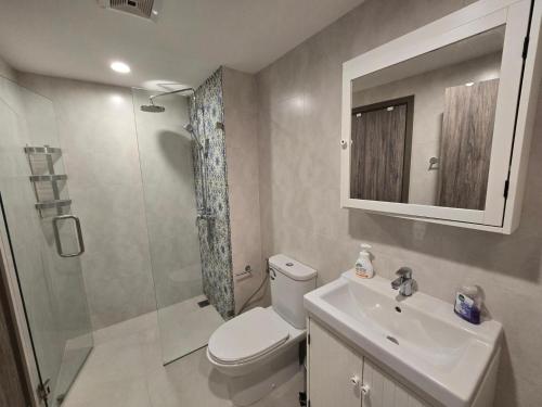 a bathroom with a toilet and a sink and a shower at Pool Side Retreat 1 BED - TC-B105 in Nai Yang Beach