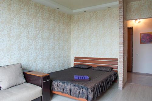ein Schlafzimmer mit einem Bett und einem Stuhl darin in der Unterkunft Apartment on Bogatyrskaya 6a in Kiew