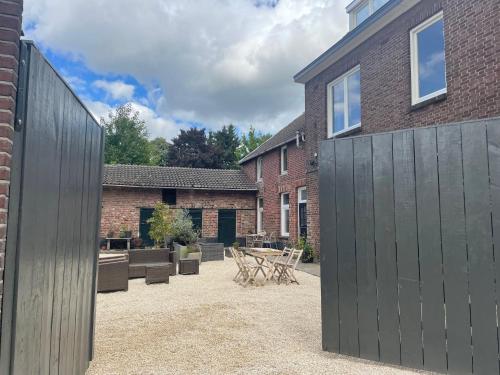 a courtyard with a wooden fence and a brick building at Fijn, recent volledig gerenoveerd appartement in Maastricht in Maastricht