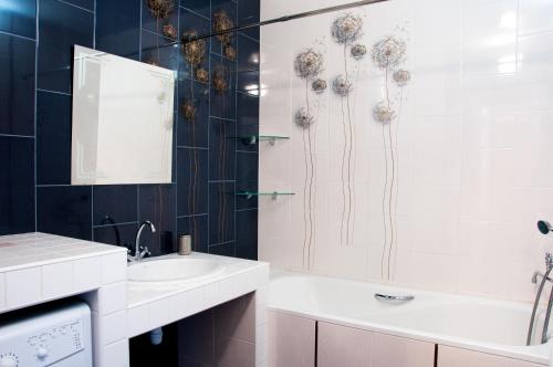 La salle de bains est pourvue d'une baignoire, d'un lavabo et d'une douche. dans l'établissement Apartment on Bogatyrskaya 6a, à Kiev