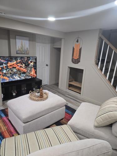 a living room with a flat screen tv and a couch at The Nook Suite in Hackensack