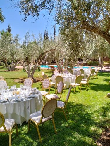 a set of tables and chairs with white tablecloths at Riad Sidi Hicham in Marrakech