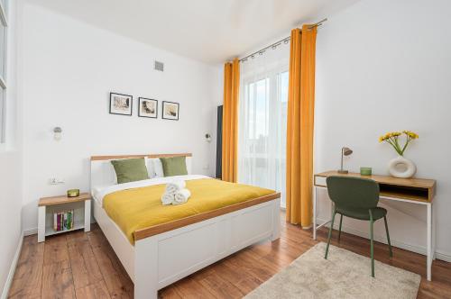 a bedroom with a bed and a desk and a chair at Lumina Charming 3-room apartment in the center of Warsaw in Warsaw