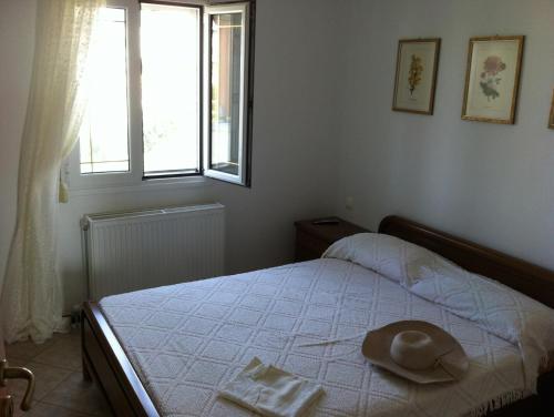 a bedroom with a bed with a hat on it at Family Apartment Ammoudi in Agia Pelagia