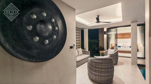 a living room with a large black disk on the wall at Santi Tara Villas in Amphoe Koh Samui