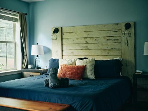 a bedroom with a blue bed with a wooden headboard at Visit Chill House 15 miles from Windham Hot Tub and Ping Pong in Cairo