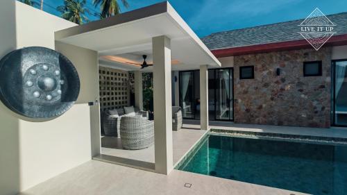 a villa with a swimming pool and a house at Santi Tara Villas in Amphoe Koh Samui