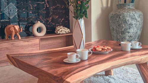 a wooden table with coffee cups and a plate of food at Santi Tara Villas in Amphoe Koh Samui