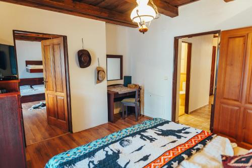 a bedroom with a bed and a desk in it at Ranč pod Ostrou Skalou in Stratená