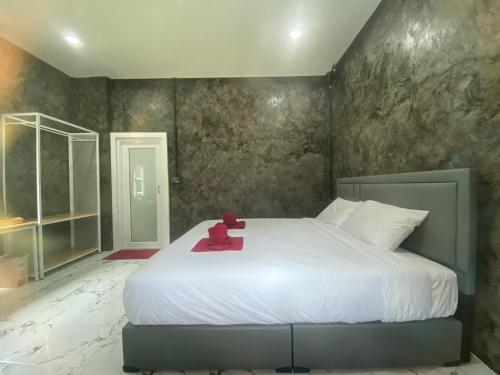a bedroom with a bed with a teddy bear on it at Khaosok Foresta Resort in Phanom