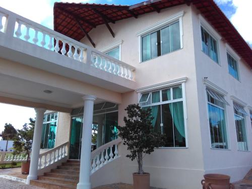 a white house with a tree in front of it at Hotel Acarau Riviera in Acaraú