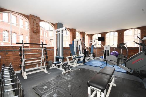 a gym with equipment in a brick building with windows at Kelham River View Home in Neepsend
